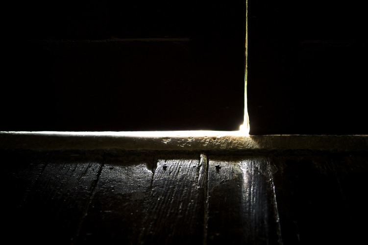 A crack in the door reveals light in the darkness